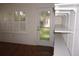 Living room featuring hardwood floors, shelves, a decorative glass door, and shuttered windows at 11091 Sw 73Rd Ct, Ocala, FL 34476