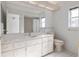 Bathroom vanity with marble countertop, large mirror and bright natural lighting at 11625 Sw 71St Cir, Ocala, FL 34476