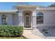 Close-up of home's entry showing the front door, side windows, and manicured landscaping at 11625 Sw 71St Cir, Ocala, FL 34476