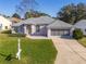 Inviting one-story home with lush green lawn, screen garage and a welcoming front entrance at 11625 Sw 71St Cir, Ocala, FL 34476