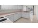 Kitchen featuring white appliances and cabinets with a pink countertop and tile floors at 11625 Sw 71St Cir, Ocala, FL 34476