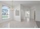 Bright living room with arched entry and window with natural light and neutral tile floors at 11625 Sw 71St Cir, Ocala, FL 34476