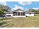 Rear exterior view showcasing screened lanai and outdoor dining area, perfect for entertaining at 165 Ne 43Rd Ave, Ocala, FL 34470