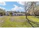 Charming single-story home with a well-maintained lawn and mature trees under a partly cloudy sky at 165 Ne 43Rd Ave, Ocala, FL 34470