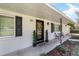 Charming brick home featuring black shutters and a welcoming front porch with decorative plants and a wreath at 165 Ne 43Rd Ave, Ocala, FL 34470