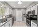 Well-lit kitchen featuring stainless steel appliances, white cabinets, and granite countertops at 165 Ne 43Rd Ave, Ocala, FL 34470