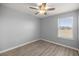 Bedroom featuring wood look flooring, neutral paint, ceiling fan and a sunlit window at 1681 Nw 44Th Ct Rd, Ocala, FL 34482