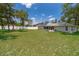 Large grassy backyard enclosed by a white fence, featuring a screened porch and mature trees at 18 Fir Trail Pass, Ocala, FL 34472