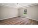 A bright, neutral bedroom featuring hardwood floors, a ceiling fan, and a window with natural light at 206 Emerald Rd, Ocala, FL 34472