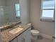 Bright bathroom featuring a granite countertop sink, modern fixtures, and a combination shower and tub at 2150 Nw 23Rd Loop, Ocala, FL 34475