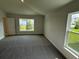 This is a bedroom with neutral walls, gray carpet, base trim, two windows and a white door at 2150 Nw 23Rd Loop, Ocala, FL 34475