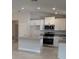 An open kitchen boasts stainless appliances, white cabinets, tile floors, and granite countertops at 2150 Nw 23Rd Loop, Ocala, FL 34475