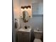 Traditional bathroom featuring white wainscoting, vanity, updated lighting, oval mirror, and medicine cabinet at 21615 Sw Raintree St, Dunnellon, FL 34431