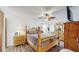 Bedroom offering a rustic wooden bed frame, dressers, and a leaf-style ceiling fan at 21615 Sw Raintree St, Dunnellon, FL 34431