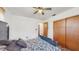 Bedroom with a ceiling fan, a dark wood closet, and a black and white floral bedspread at 21615 Sw Raintree St, Dunnellon, FL 34431