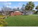 Spacious front lawn and exterior view of this single-story brick home with carport at 21615 Sw Raintree St, Dunnellon, FL 34431