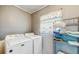 Functional laundry area featuring modern washing and drying machines with shelving at 21615 Sw Raintree St, Dunnellon, FL 34431