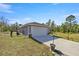 Home exterior featuring a well-maintained lawn and an attached two-car garage at 22242 Sw Marine Blvd, Dunnellon, FL 34431