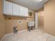 Functional laundry room with sink, tile flooring, and storage cabinets for maximum convenience at 2301 Se 24Th Ave, Ocala, FL 34471