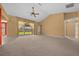 Spacious living room featuring neutral carpeting, a ceiling fan, and sliding glass doors at 2301 Se 24Th Ave, Ocala, FL 34471