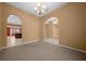 Carpeted living room featuring archway, chandelier, and neutral color scheme at 2301 Se 24Th Ave, Ocala, FL 34471