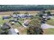 Aerial view of homes, foliage, and a tree-lined farm field in the distance at 328 Oak Track Run, Ocala, FL 34472