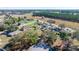 An aerial view shows houses interspersed with trees and a distant school at 328 Oak Track Run, Ocala, FL 34472