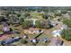 An aerial view shows a house with mature trees and a neighboring lake at 328 Oak Track Run, Ocala, FL 34472