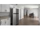 Open kitchen with stainless steel refrigerator flowing into the dining area with wood grain flooring at 328 Oak Track Run, Ocala, FL 34472