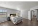 Cozy main bedroom featuring wood-look floors, bedside lamps, and a view from two windows at 328 Oak Track Run, Ocala, FL 34472