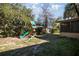 Wooden playset with slide and swingset in fenced backyard under blue sky at 3301 Se 32Nd Ave, Ocala, FL 34471