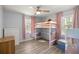 Bright bedroom features a loft bed, ceiling fan, and charming pink accents at 3301 Se 32Nd Ave, Ocala, FL 34471