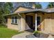 Close-up of a charming front porch with a wooden door, bench, and a flower pot, exuding a cozy welcome at 3301 Se 32Nd Ave, Ocala, FL 34471