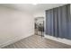 View of the living room features light wood-look flooring, a grey curtain and view to the kitchen at 3301 Se 32Nd Ave, Ocala, FL 34471