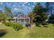 View of screened in pool area surrounded by healthy green grass and lush landscaping at 3301 Se 32Nd Ave, Ocala, FL 34471