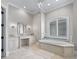 Elegant bathroom with marble floors, a soaking tub, vanity and a chandelier at 3848 Nw 85Th Ter, Ocala, FL 34482