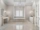 Elegant bathroom featuring marble floors, chandelier, soaking tub and vanities at 3848 Nw 85Th Ter, Ocala, FL 34482