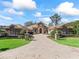 Stately home featuring a paved driveway, manicured landscaping, and stone accents, showcasing curb appeal at 3848 Nw 85Th Ter, Ocala, FL 34482