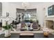 Elegant living room with grand piano, fireplace, and a large window overlooking a lush yard at 3848 Nw 85Th Ter, Ocala, FL 34482