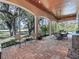 View of the beautiful screened-in patio with wood ceilings, brick floors, and outdoor dining at 3848 Nw 85Th Ter, Ocala, FL 34482