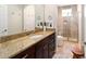 Bathroom with granite countertop, dark wood vanity, tiled shower with glass door, and neutral color palette at 4103 Se 10Th Ave, Ocala, FL 34480