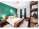 Stylish bedroom featuring a wood-framed bed, green accent wall, and thoughtfully placed books at 4103 Se 10Th Ave, Ocala, FL 34480
