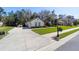 Charming home boasts a pristine lawn, a long driveway and a basketball hoop on the side of the garage at 4103 Se 10Th Ave, Ocala, FL 34480