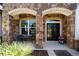 Inviting front porch featuring stone columns, a cozy seating area, and decorative plants at 4103 Se 10Th Ave, Ocala, FL 34480