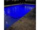 A lovely in-ground pool is lit up with blue underwater lights at night, creating a relaxing oasis at 4103 Se 10Th Ave, Ocala, FL 34480