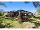 Backyard view of covered pool and landscaped garden, surrounded by lush green grass at 4103 Se 10Th Ave, Ocala, FL 34480