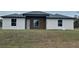 Modern single-story home with a combination of stucco and wood exterior and a well-maintained lawn at 4524 Sw 110Th St, Ocala, FL 34476