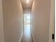 A hallway with beige walls, wood-look tile floors and views to another room at 4524 Sw 110Th St, Ocala, FL 34476