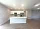 Bright kitchen features an island, stainless appliances, quartz counters, and wood-look tile floors at 4524 Sw 110Th St, Ocala, FL 34476