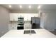 Bright kitchen features an island, stainless appliances, quartz counters, and wood-look tile floors at 4524 Sw 110Th St, Ocala, FL 34476